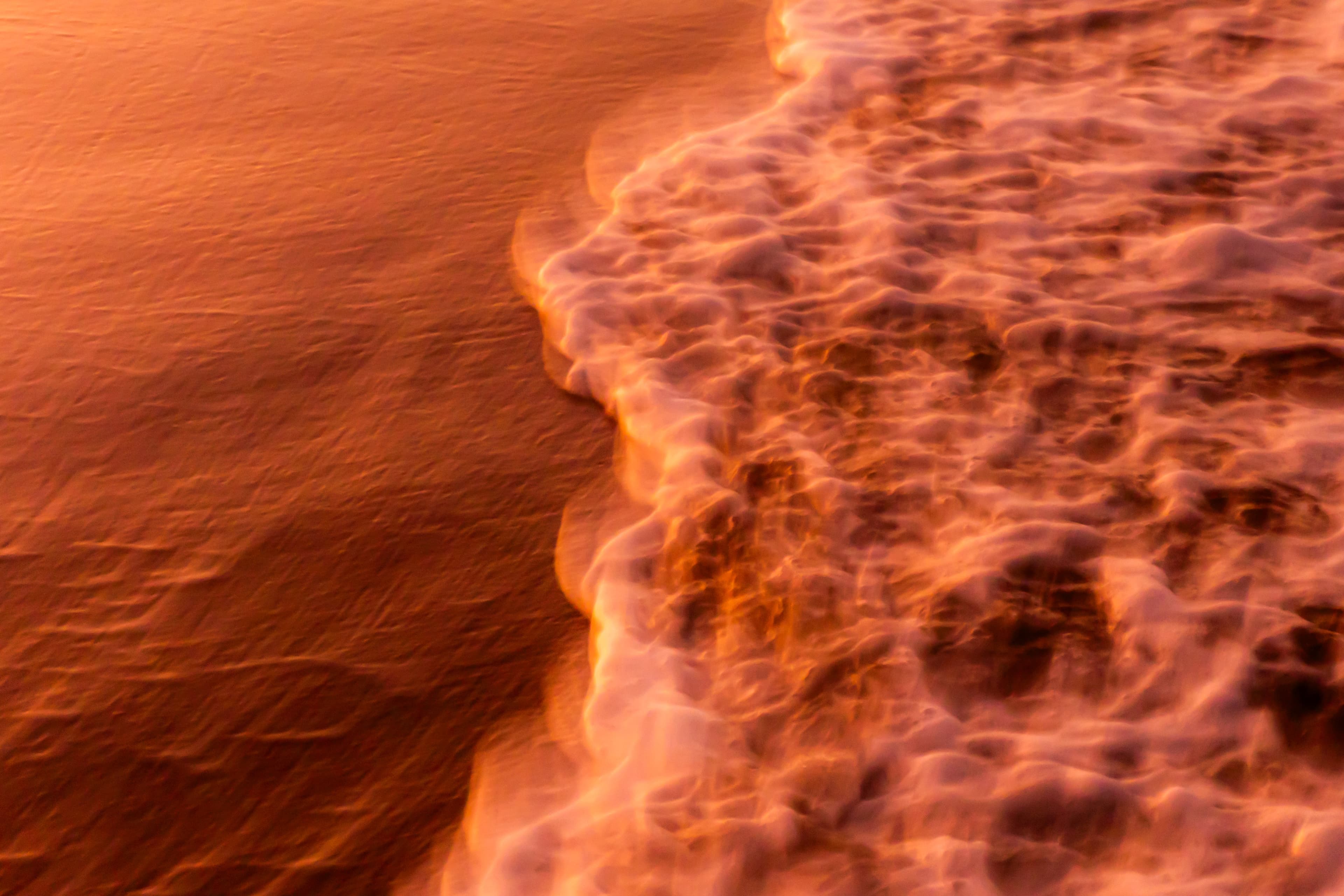 Fiery orange sunset light along the shoreline — fine art ocean photography print, Whangamata NZ.