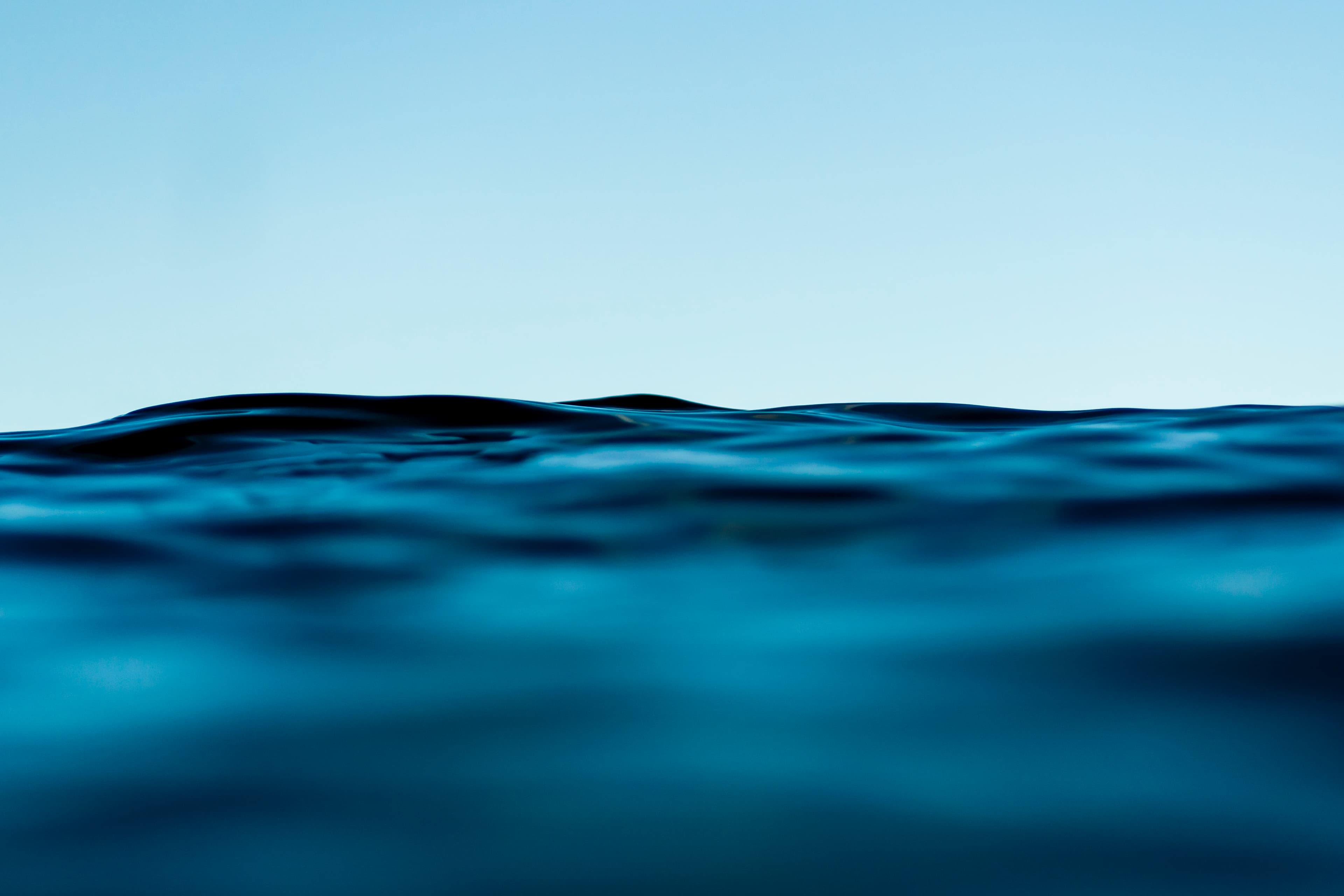 Minimalist wave line against a pale blue sky — fine art ocean photography print, Whangamata NZ.
